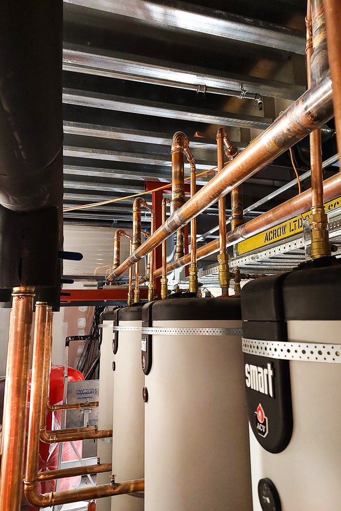 Copper pipe and water tanks in the plant room.
