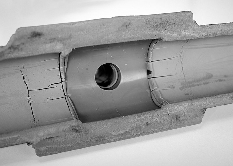 PP-R Degradation Cross Cut - At Fitting 2 A cross section of failed PP-R pipe at the joining of a Tee fitting. There are visible cracks where the fitting and pipe meet.