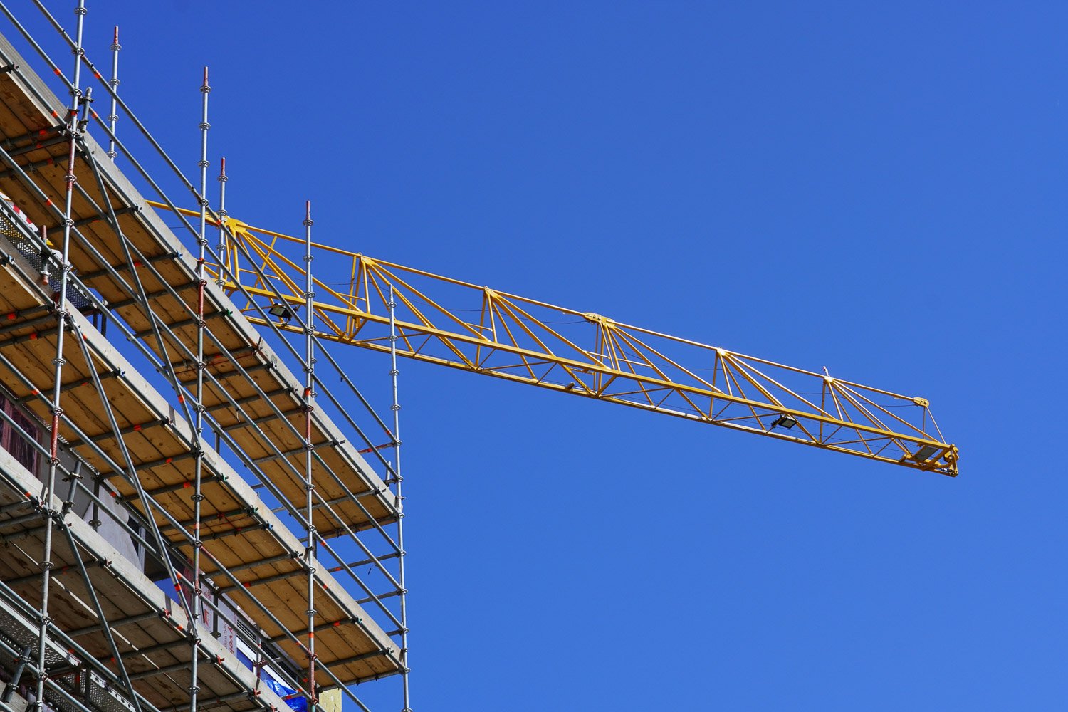 crane-over-building crane perched over building being constructed.