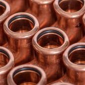 Piping-System-Hero-COPPERFIX COPPERFIX copper pipe fittings equal tees close up of them all closely together and a repetitive pattern.